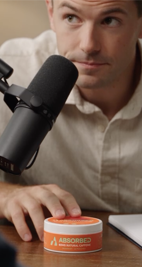 ABSORBED tin on a table beside a person and microphone